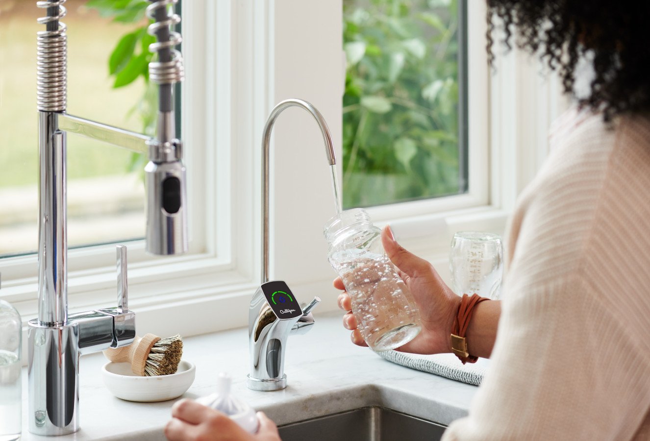 Person filling glass of water at tap with smart technology